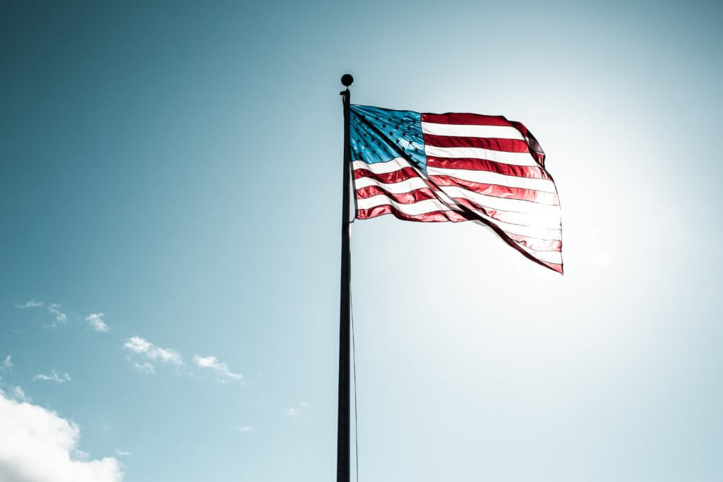 American flag flying over Washington, United States on a sunny day.