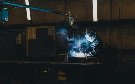 A welder at Leeco Steel works on a wind turbine project.