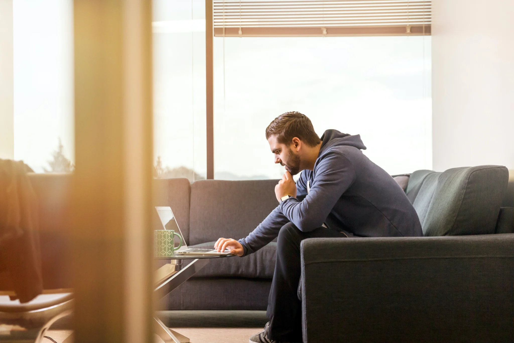 Man logging onto his laptop to access work files while working remotely.