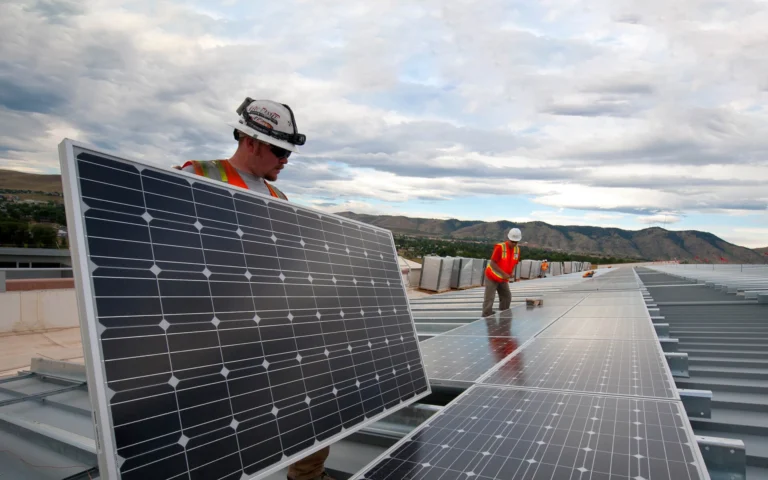Brian Lawson and Kenesaw Burwell work on panels that the Energy Department is using to leverage a Power Purchase Agreement with Sun Edison and Xcel Energy.