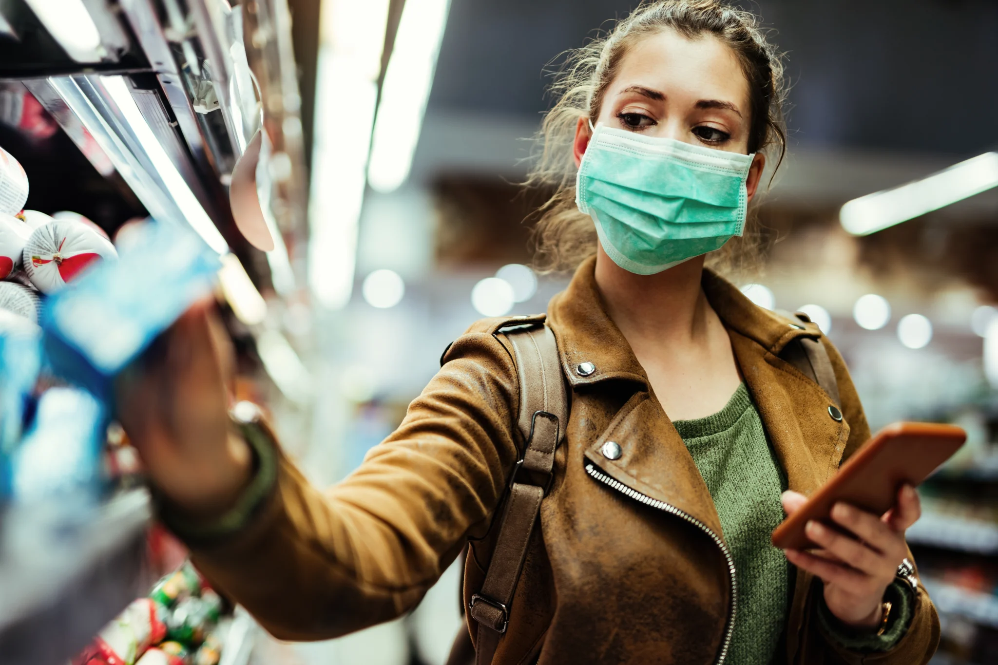 Woman wearing mask shopping at grocery store.