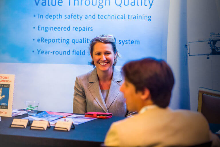 A woman smiling at a conference booth