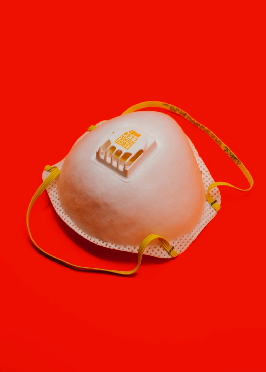 N95 face mask against a red background.