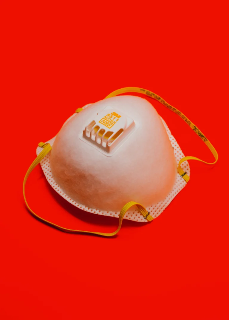 N95 face mask against a red background.