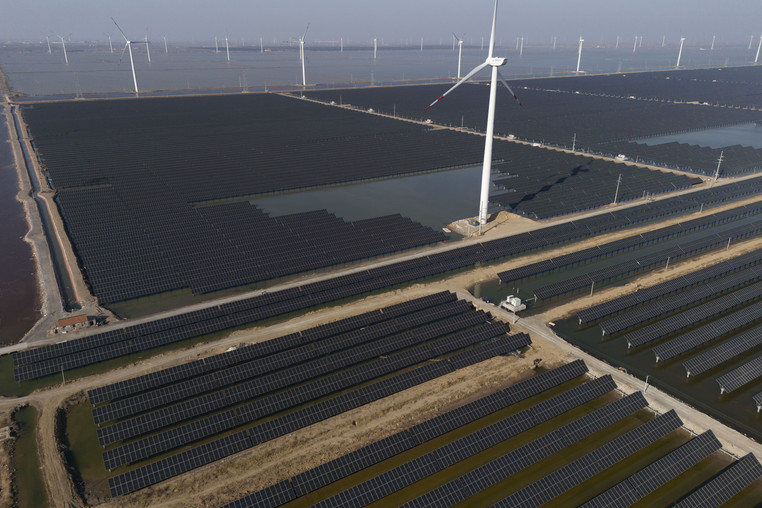 solar panels and wind turbines in a field