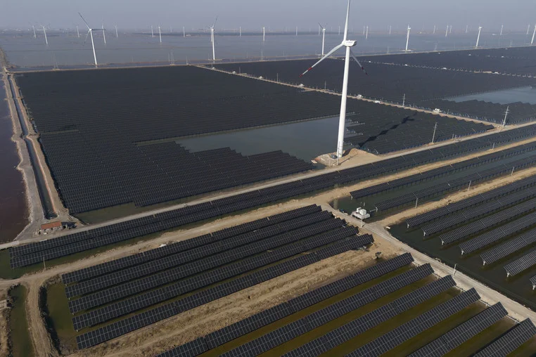 solar panels and wind turbines in a field