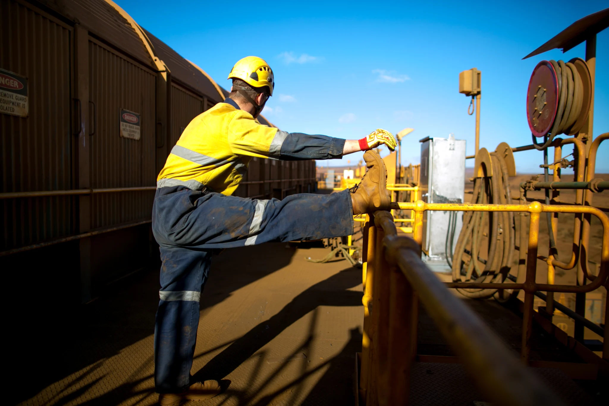 A construction worker stretching at a job site.