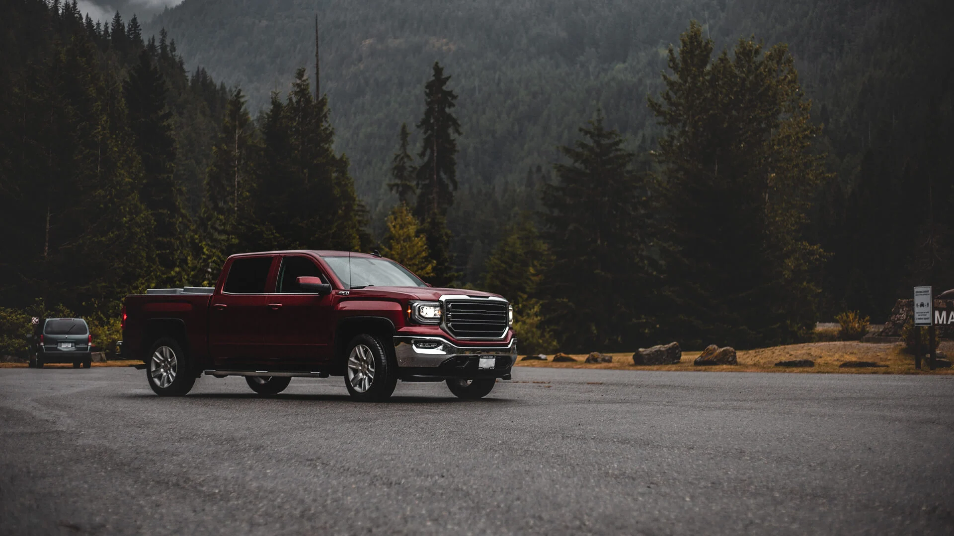 Red pickup truck parked in national park.