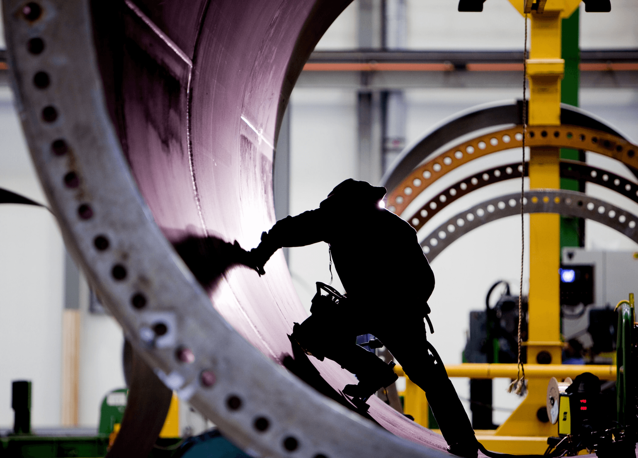 Photo of a manufacturer in shadow working on a wind turbine.