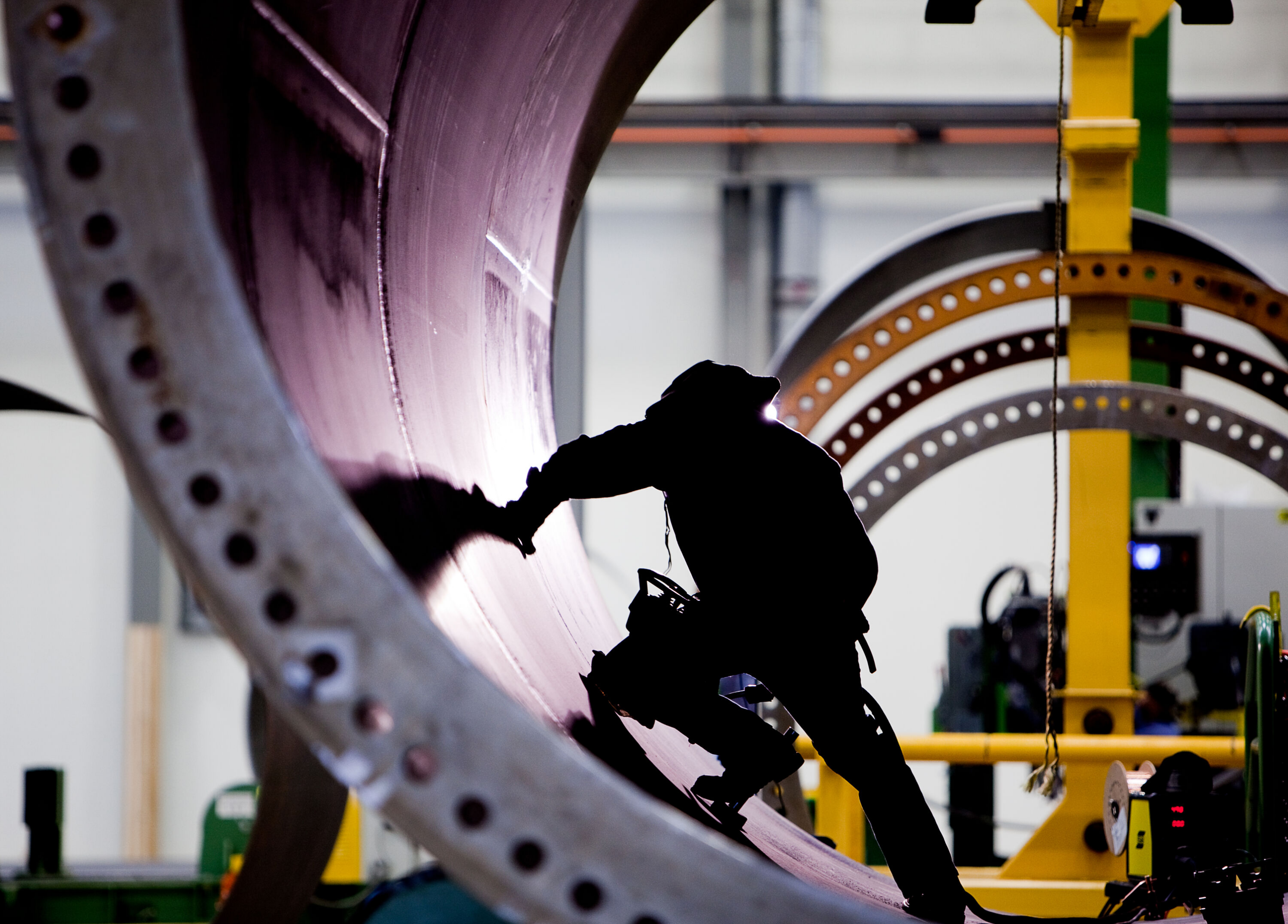 Photo of a manufacturer in shadow working on a wind turbine.