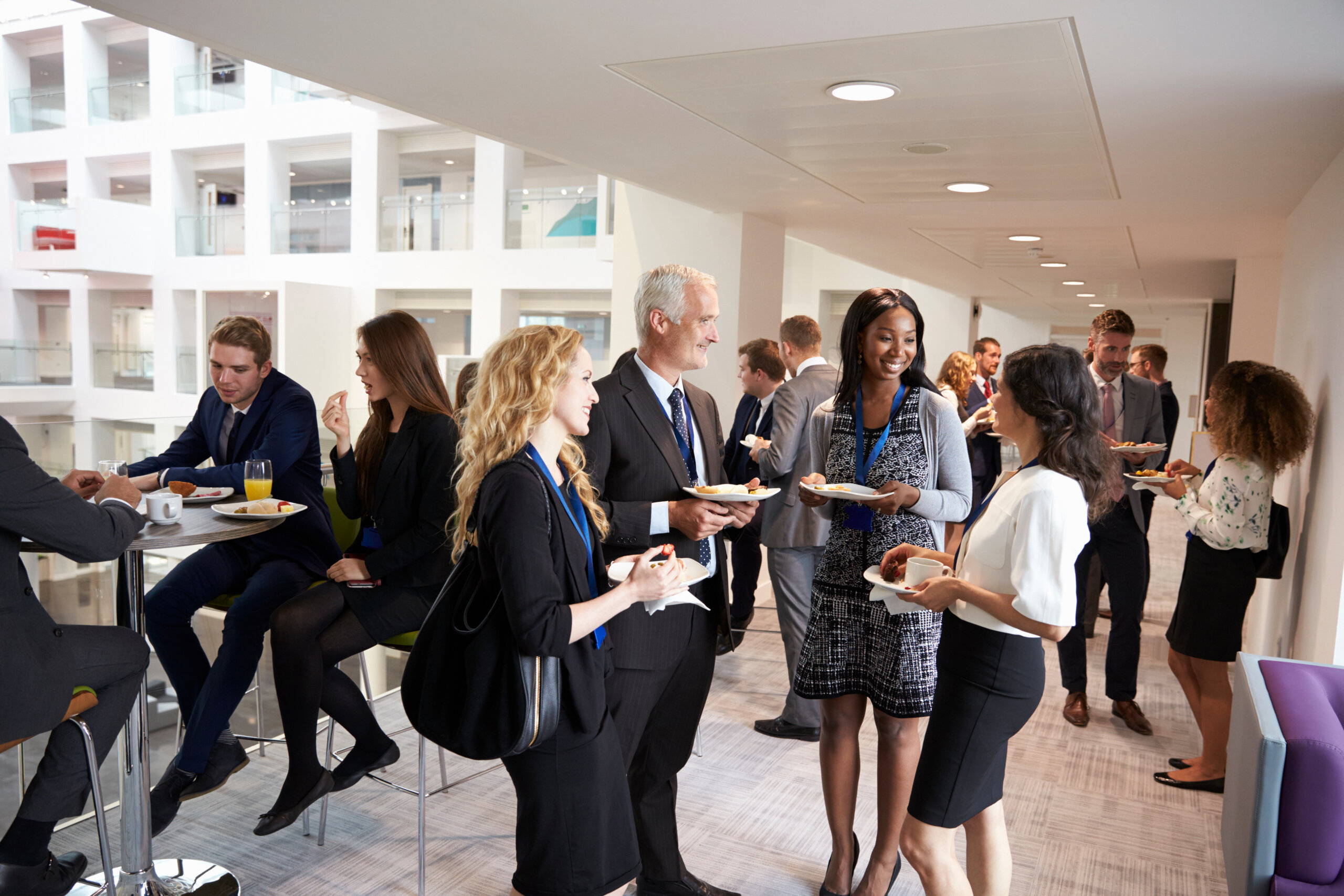 A group of conference attendees eat and talk.