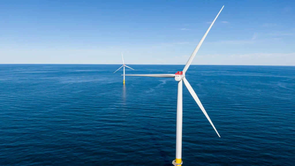 Two offshore wind turbines looking out into the ocean.
