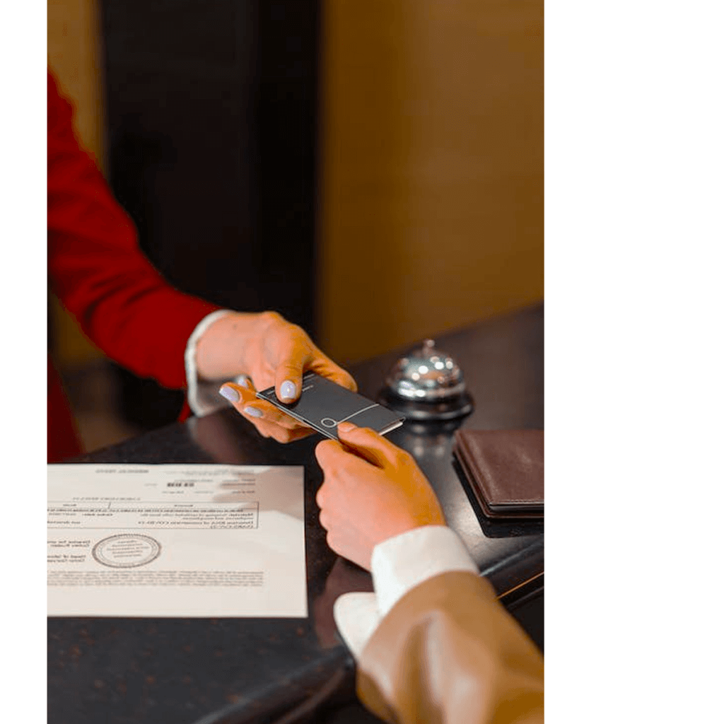 A hotel staff member handing a guest a room key.