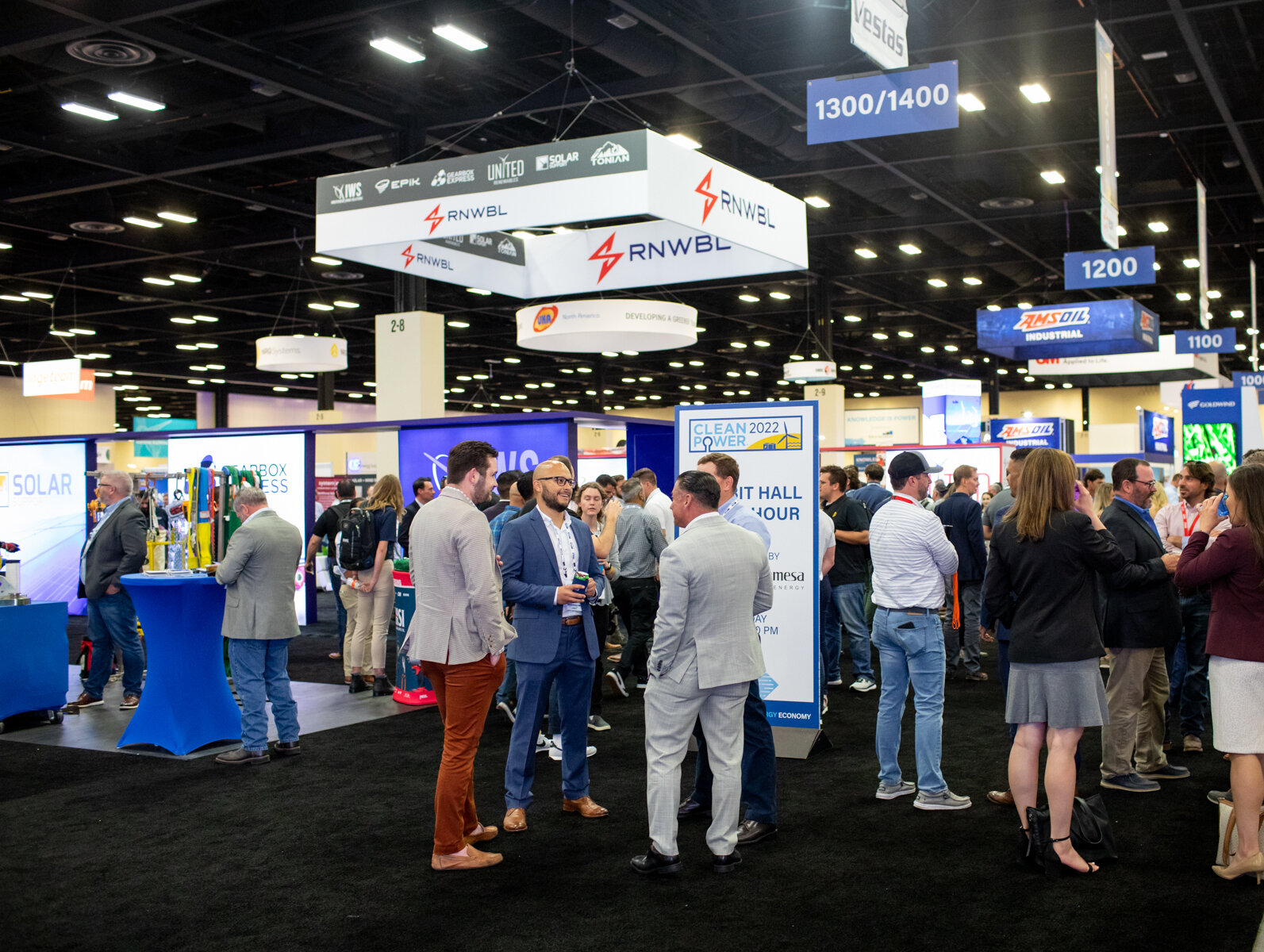 A group of conference attendees talk in ACP's exhibit hall at CLEANPOWER 2022.