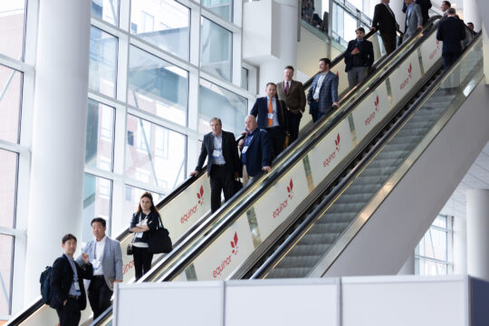 An image of ACP Conference attendees riding an escalator.
