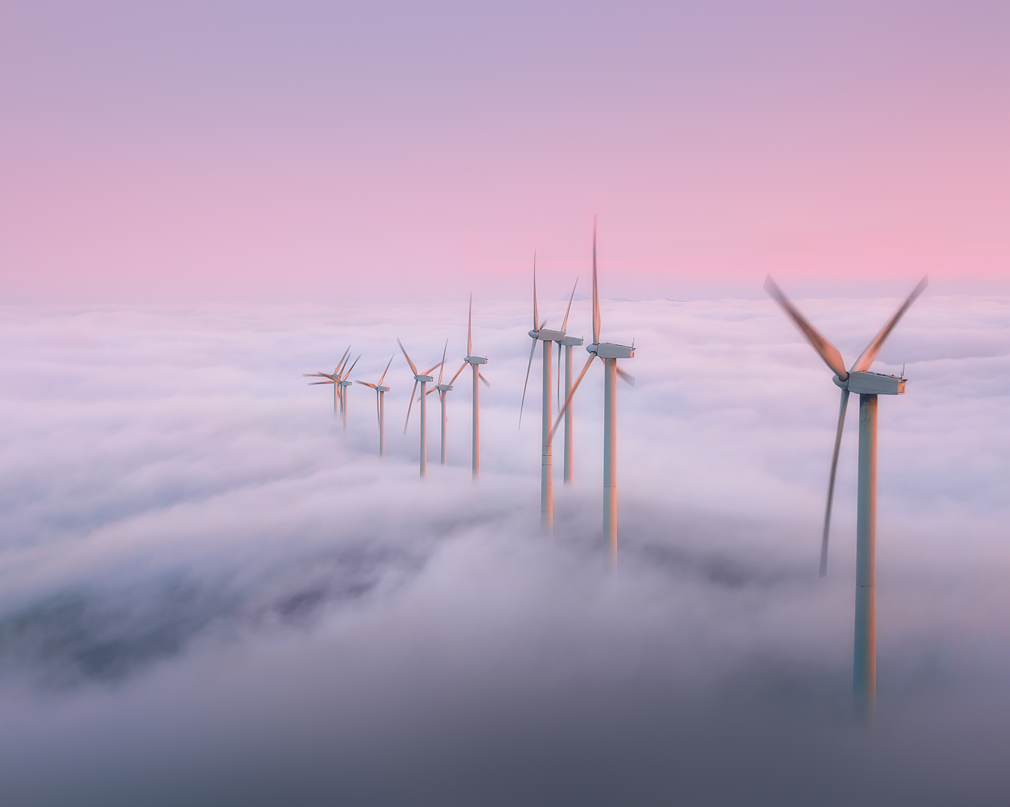 Wind Turbines Rise Above Clouds at Sunset.