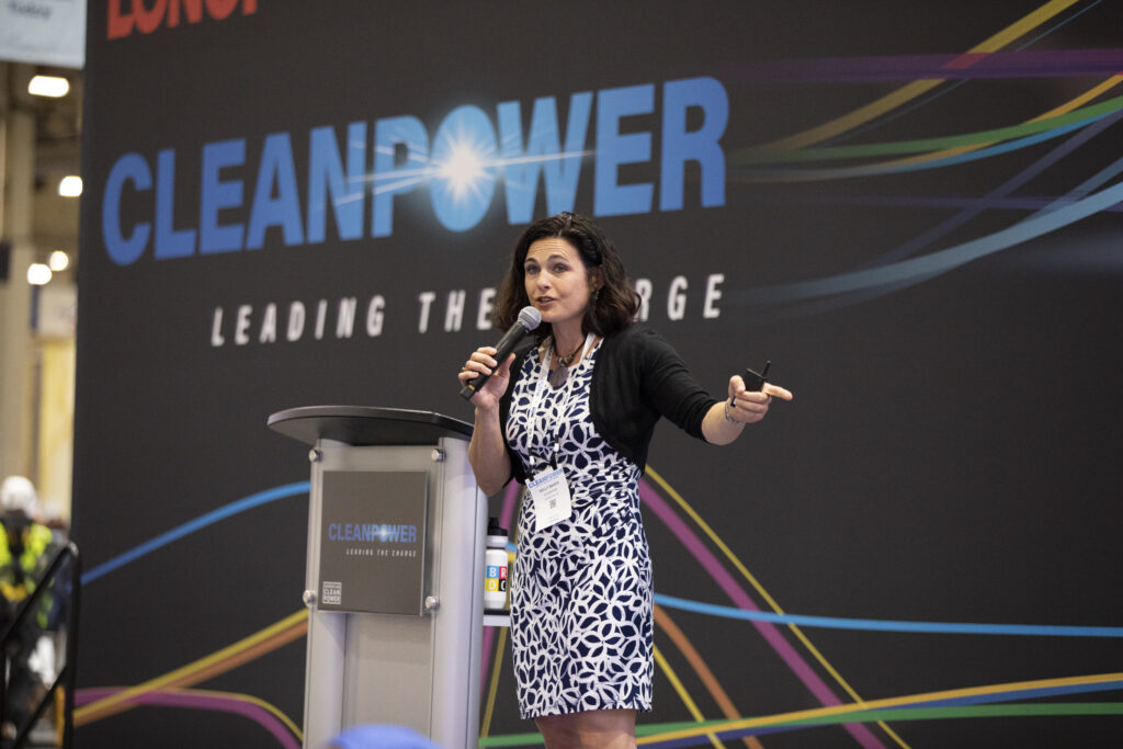 A Speaker at ACP's Clean Power Conference Presents on Stage.