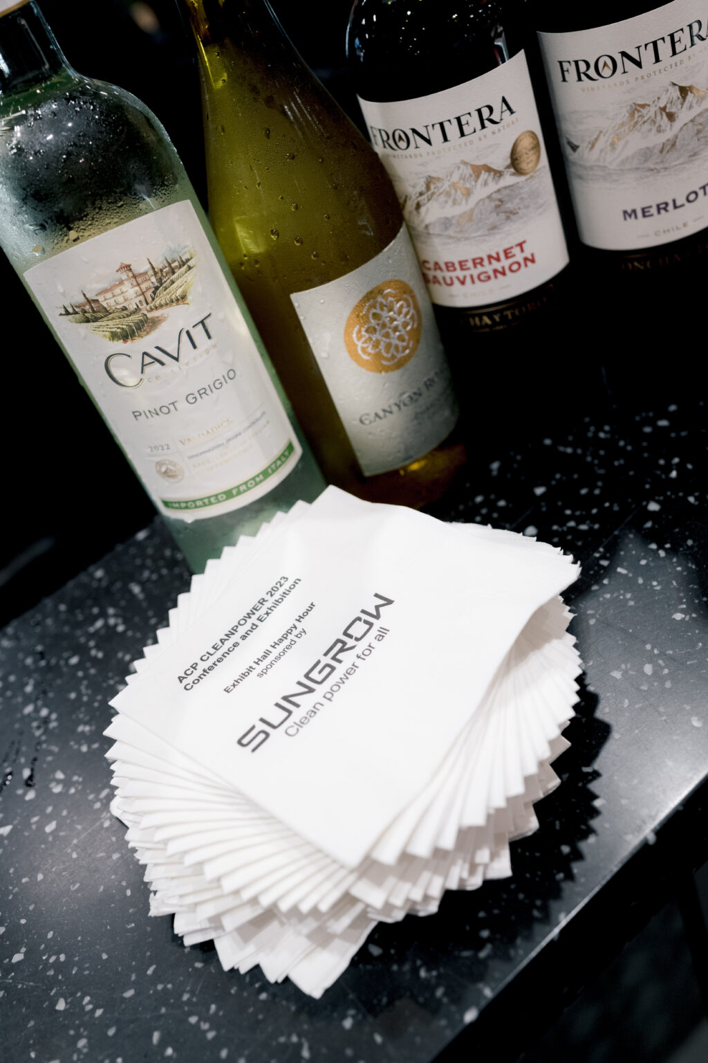 Images of napkins and bottles of alcohol branded for promotion at ACP's WINDPOWER reception.