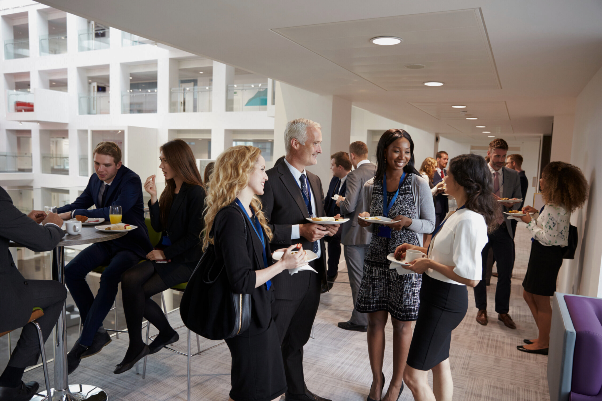 A group of conference attendees eat and talk at an event.