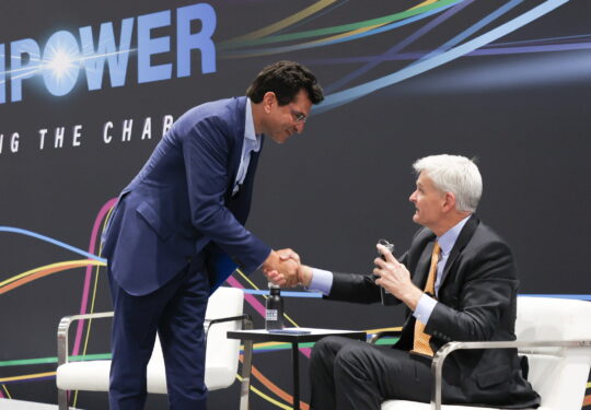 Jason Grumet and conference speaker shaking hands on ACP's Leading the Charge stage at ACP's CLEANPOWER event.