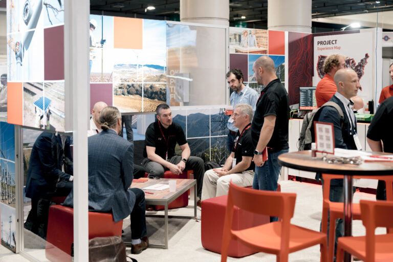 Several attendees of an ACP conference sitting and standing around chatting and networking.