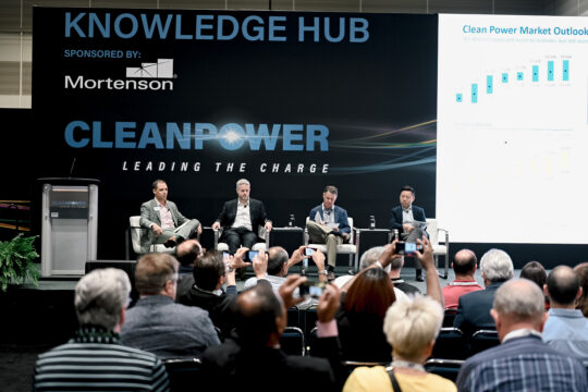 Four speakers on ACP's CLEANPOWER Conference main stage in front of a banner that says "Leading the Charge."