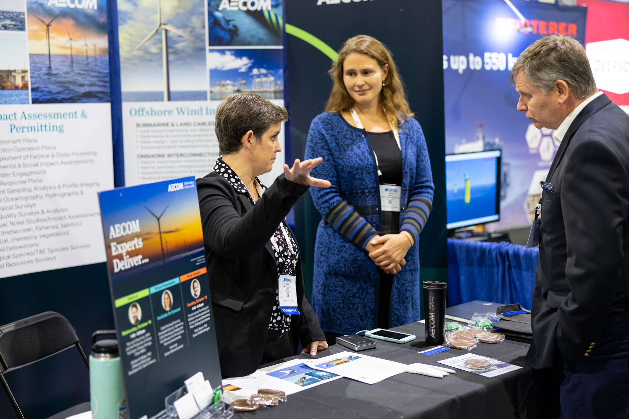 Two exhibitionists at an ACP conference discussing their products and services with a conference attendee.