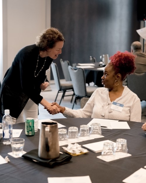 Two women shaking hands at one of the DEI events at CLEANPOWER 2023