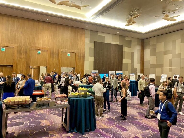 The networking reception at R&T 2022. A full hotel ballroom with poster presentations happening around the edges and networking in the middle.