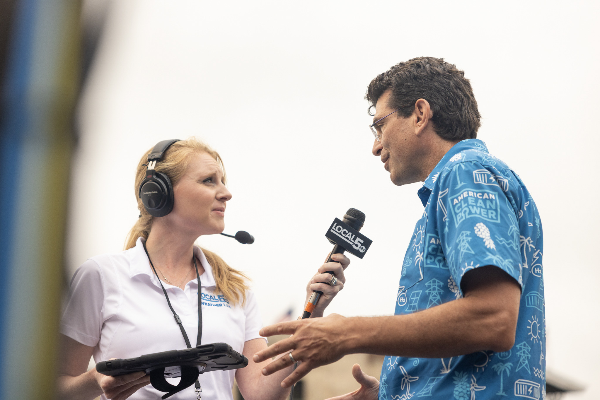 A news reporter holds a microphone up to ACP's CEO outside.