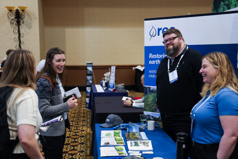 People smiling at a booth at Siting 2024