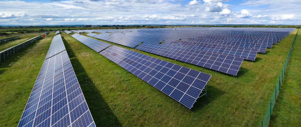 Aerial view of big sustainable electric power plant with many rows of solar photovoltaic panels for producing clean electrical energy. Renewable electricity with zero emission concept.