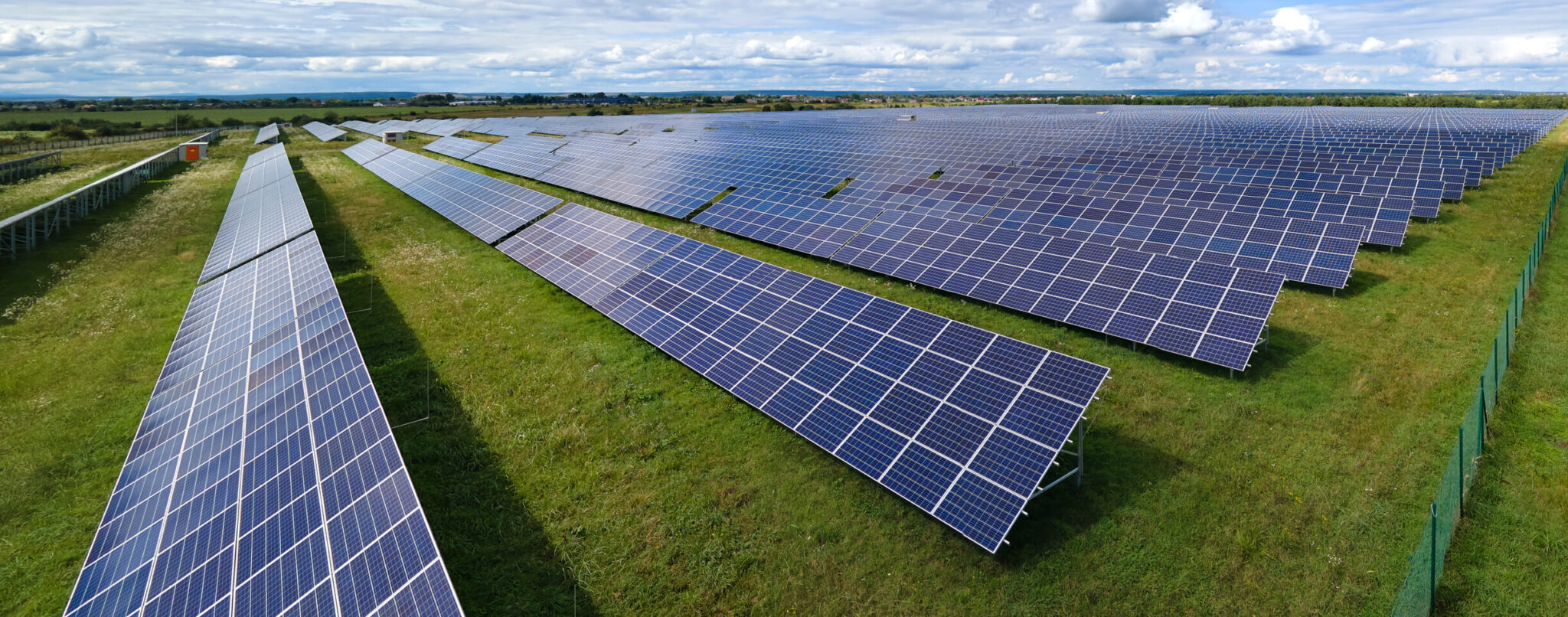 Aerial view of big sustainable electric power plant with many rows of solar photovoltaic panels for producing clean electrical energy. Renewable electricity with zero emission concept.